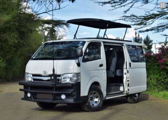 White Toyota HiAce safari minivan with pop-up roof in bush setting